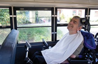 man is wheelchair on bus