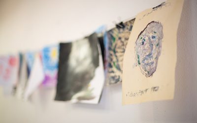 Paintings created by artists with disabilities hang to dry.