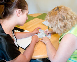 Service Coordinator helps Sabrina track expenses in a book