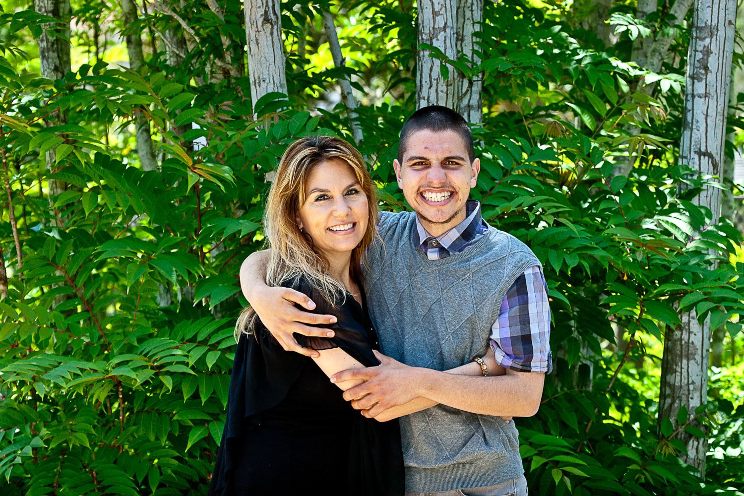 Hispanic mom hugs her teen son with Autism in the park