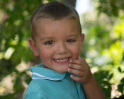 Little boy turns and smiles in the park