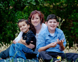 Mom poses with two sons in the park