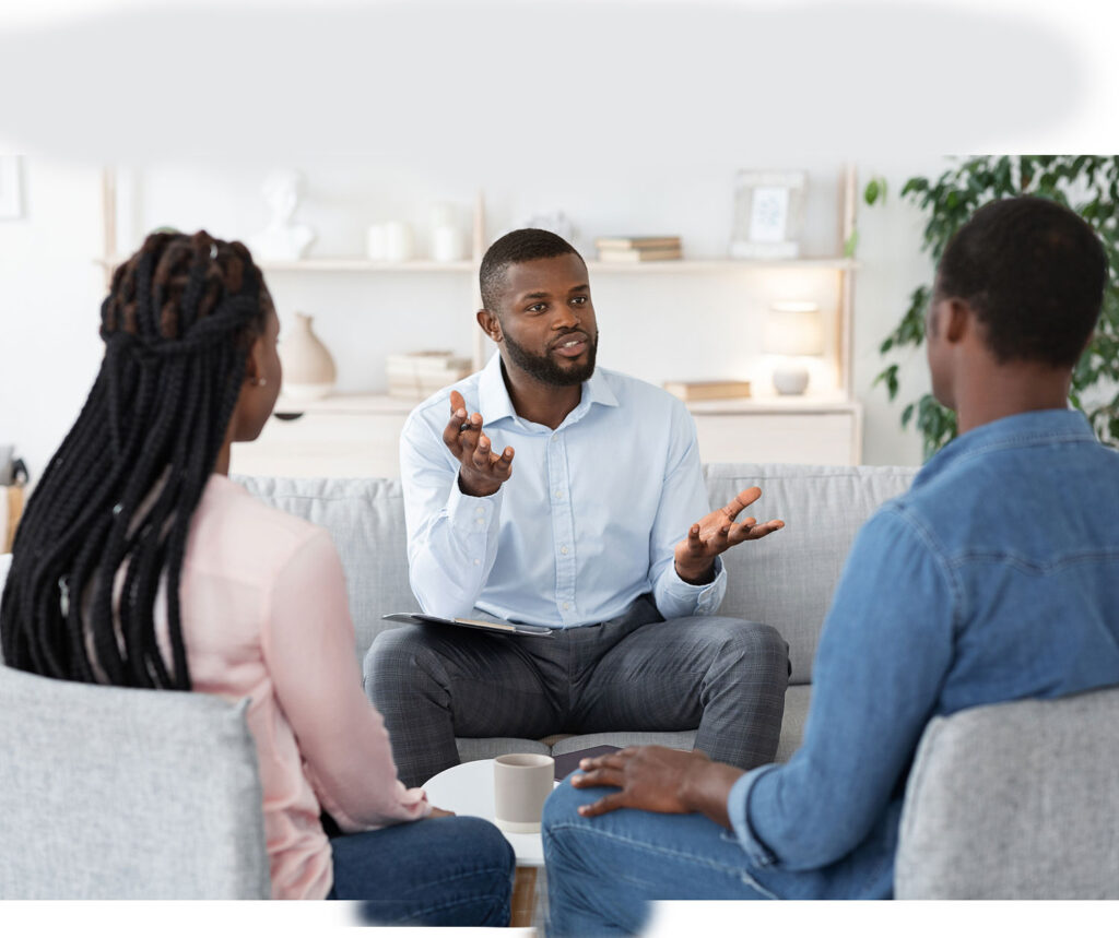 Black service coordinator talks with a couple in their home