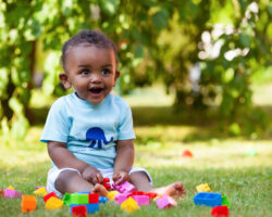 Portrait of a little african american baby boy playing outdoor in the grass