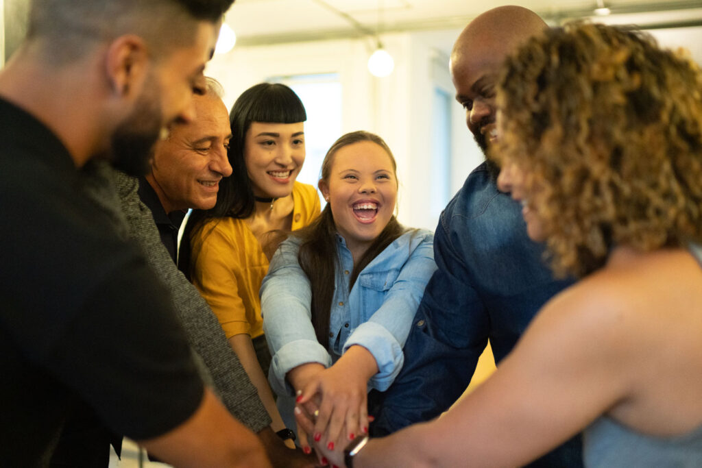 Group of mixed ethnicities and abilities all join hands for a "break"