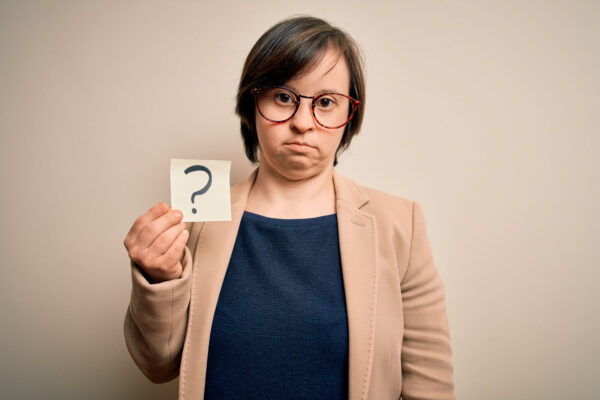 Young down syndrome business woman holding a sign with a question mark