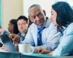 Two Service Providers have a side conversation during a meeting