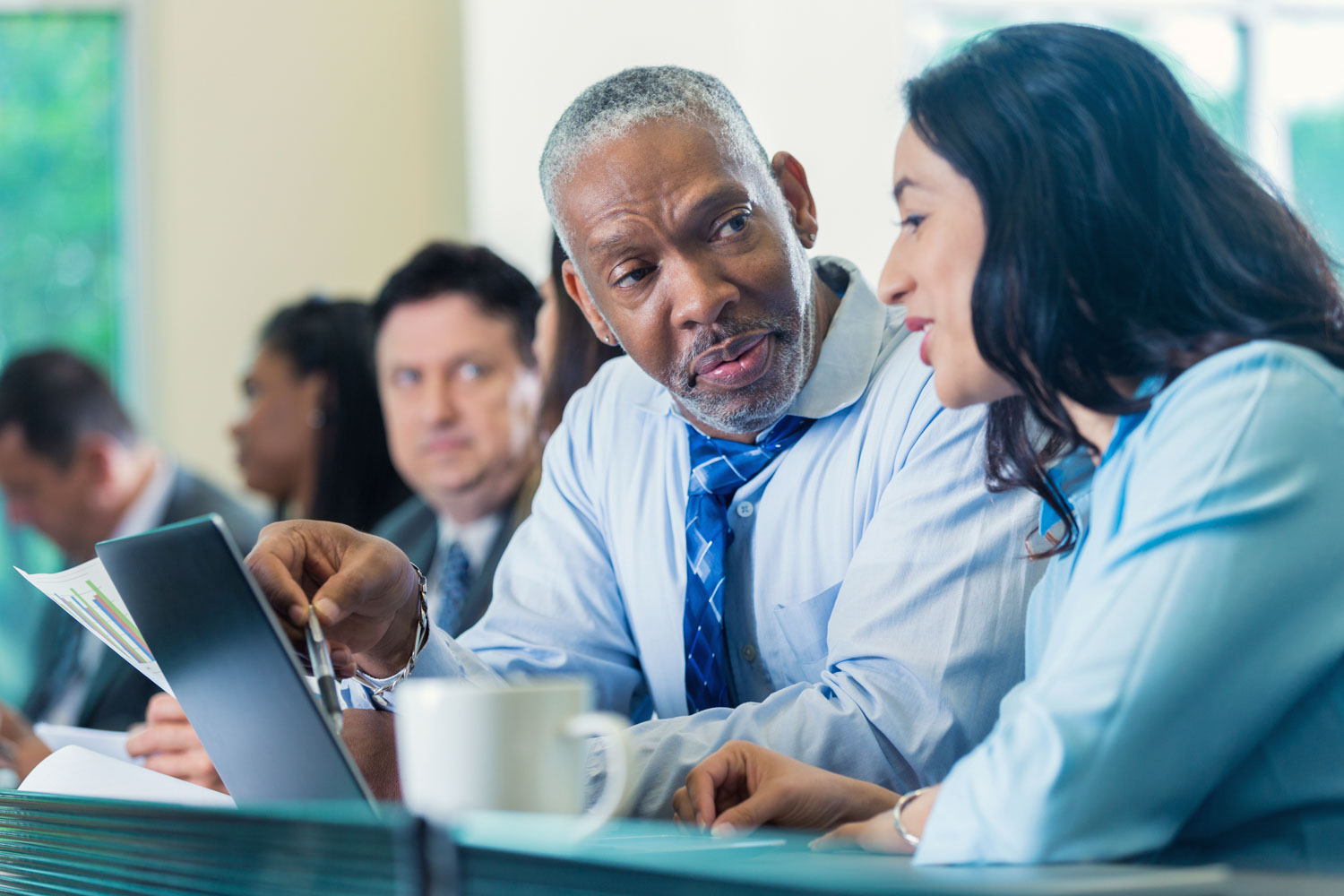 Two Service Providers have a side conversation during a meeting