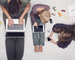 Top down view of mom and two kids, all on devices