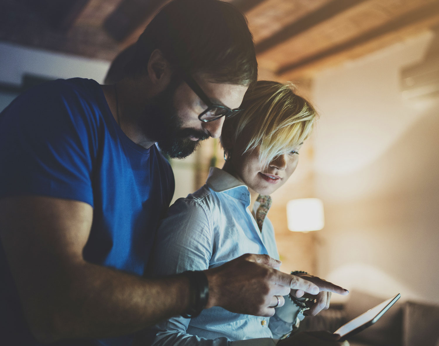 Young couple looking at table together in the evening, emergency planning