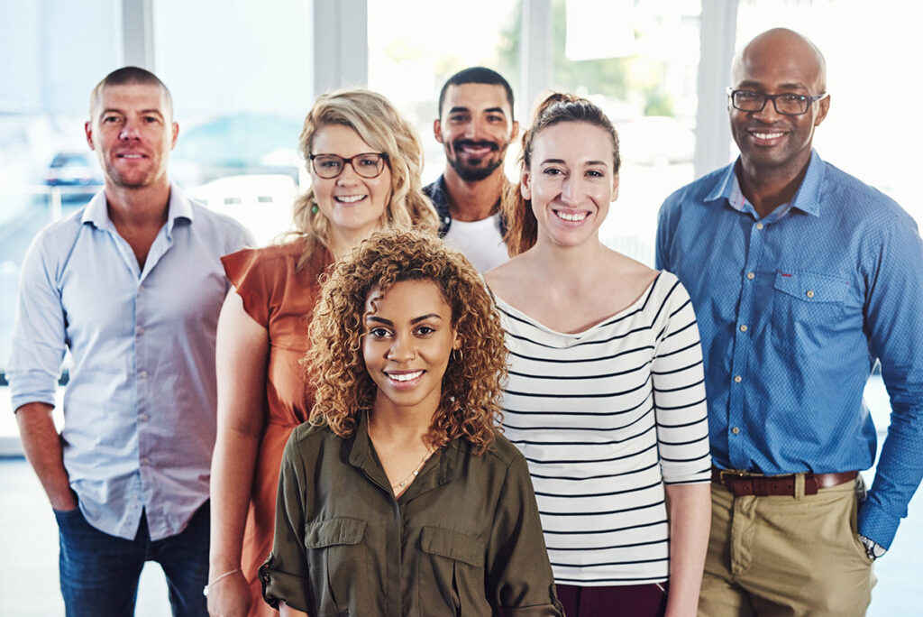 Diverse group of service coordinators smile for a photo during a training.